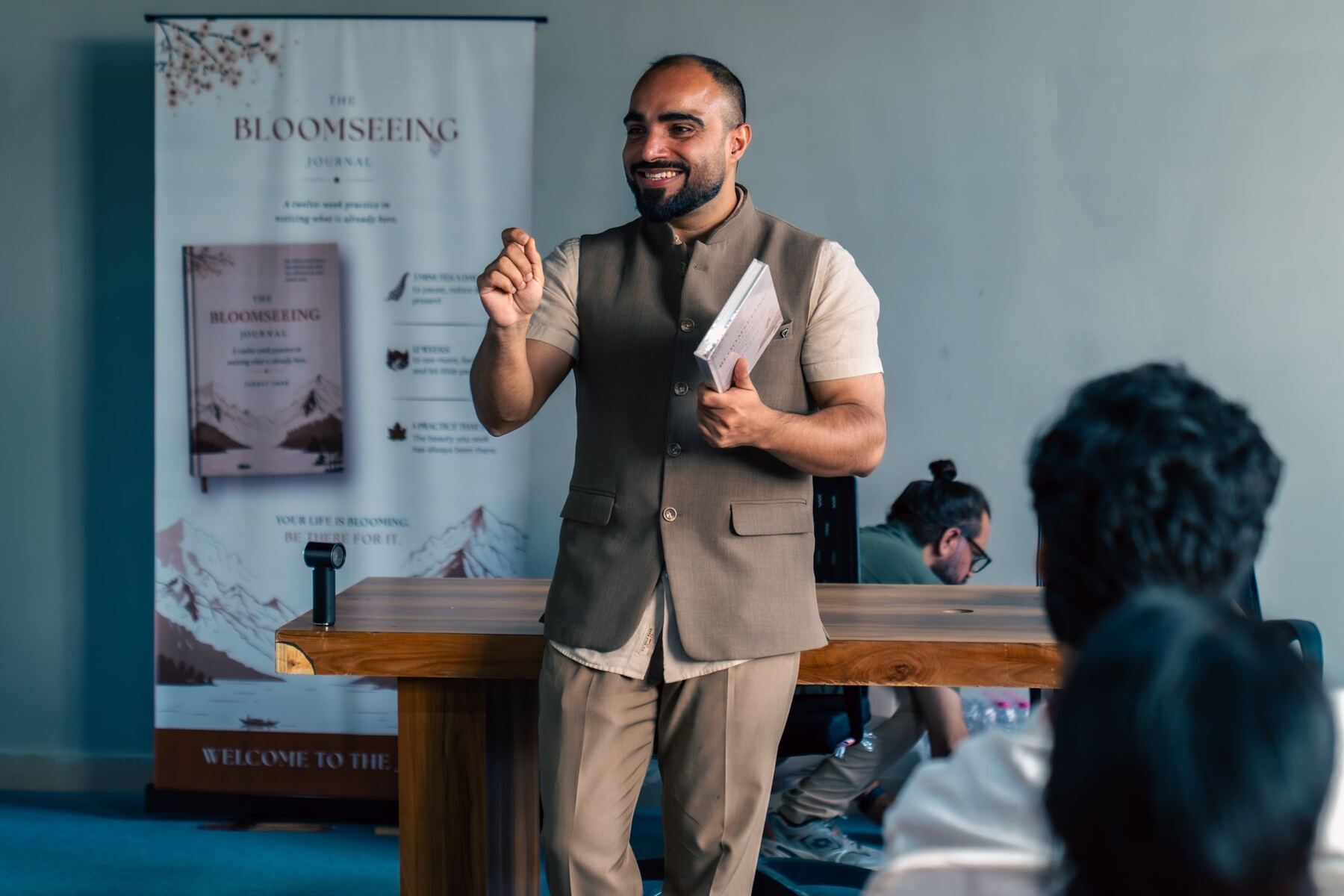 Farhat Umar smiling as he speaks at the Bloomseeing launch