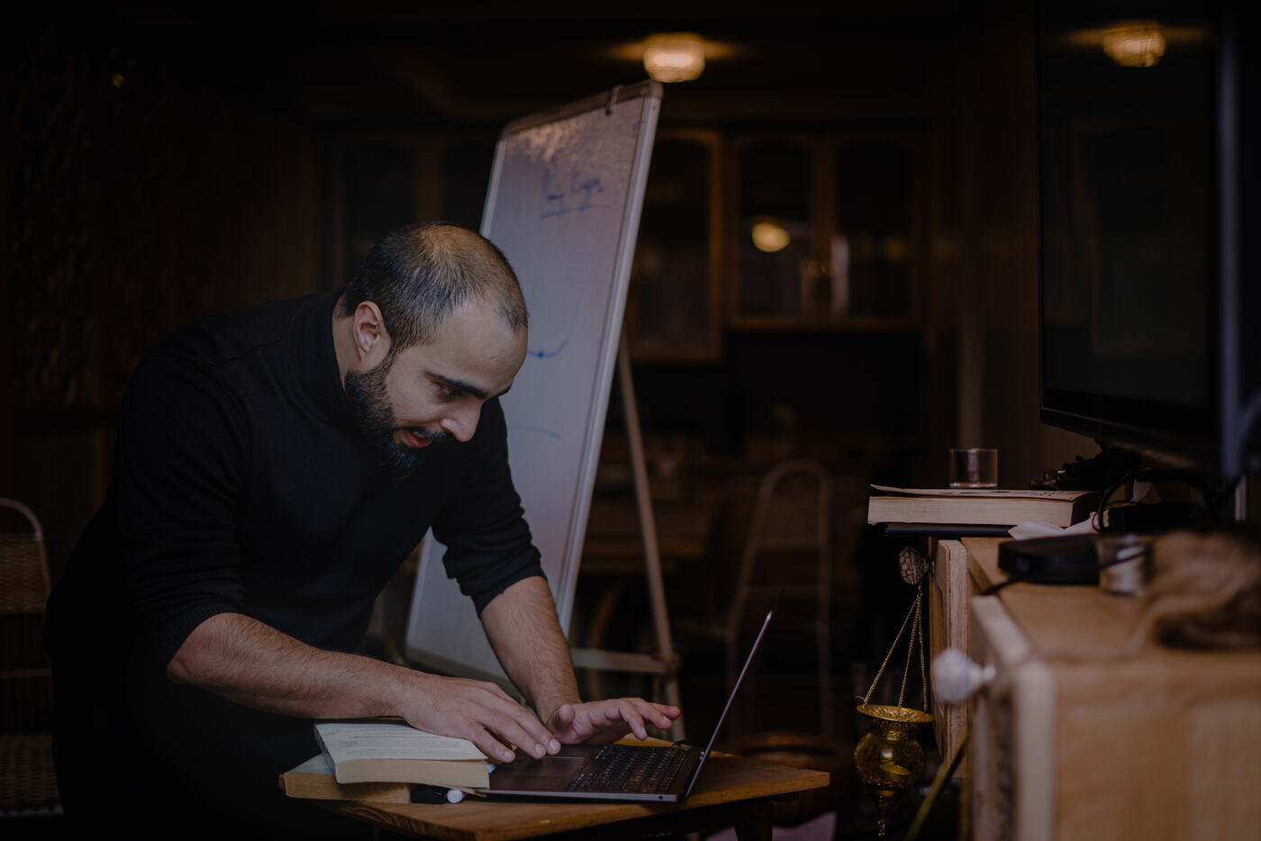 Farhat preparing at a laptop beside a flip chart