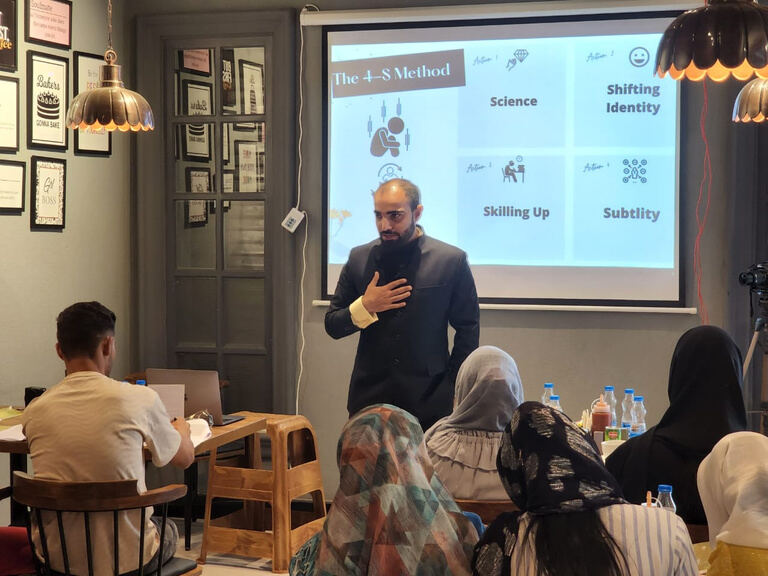 Farhat Umar teaching a workshop in front of a projected slide