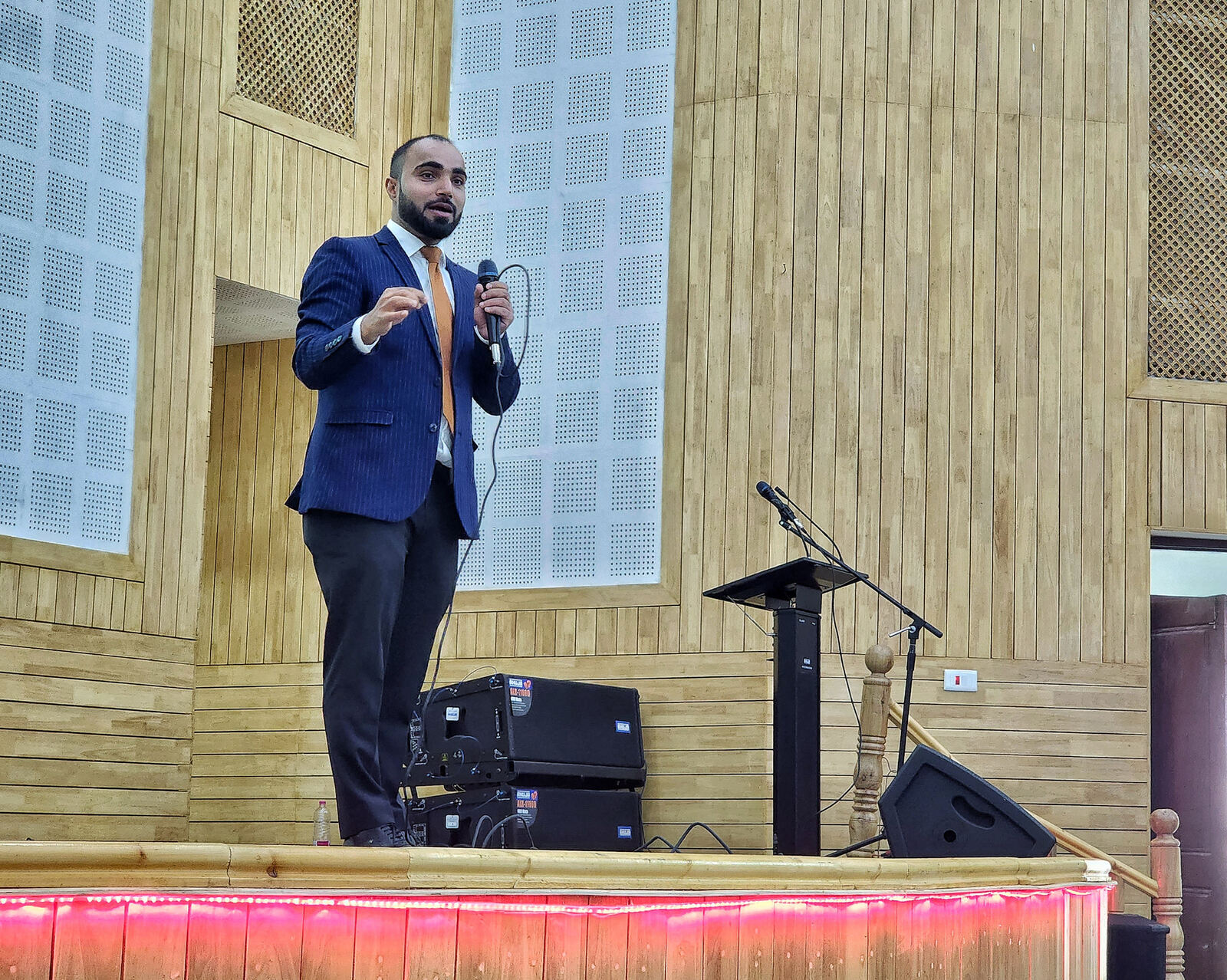 Farhat on stage holding a microphone